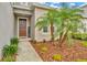 Inviting entryway with a brown front door, landscaping, and a walkway at 29762 Chapel Chase Dr, Wesley Chapel, FL 33545