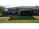 Rear exterior view, showcasing landscaping and AC unit at 317 Green Manor Dr # 38 B, Sun City Center, FL 33573