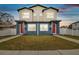 Two-story duplex with red doors, blue siding, and a well-manicured lawn at 3467 17Th S Ave, St Petersburg, FL 33701