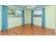 Light and airy bedroom with wood floors and teal curtains at 3628 Holiday Lake Dr, Holiday, FL 34691