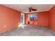 Bedroom with orange walls, carpeting, and sliding glass doors to the pool at 3628 Holiday Lake Dr, Holiday, FL 34691