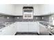 White shaker cabinets, granite counters, and gray tile backsplash at 3628 Holiday Lake Dr, Holiday, FL 34691