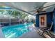 Inviting screened pool area with a relaxing rocking chair at 3628 Holiday Lake Dr, Holiday, FL 34691