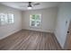 Bright bedroom with wood-look floors, plantation shutters, and ceiling fan at 414 S Shore Crest Dr, Tampa, FL 33609