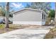 Gray manufactured home with a concrete driveway and side yard at 5234 Yellow Pine N St, St Petersburg, FL 33709