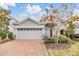 Gray house with brick paver driveway and landscaping at 5613 Del Coronado Dr, Apollo Beach, FL 33572
