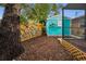 Landscaped backyard with a teal shed and wooden fence at 663 Athens St, Dunedin, FL 34698