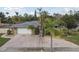 Single-story home with a large driveway and lush landscaping at 775 Rolling Hills Dr, Palm Harbor, FL 34683