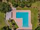 L-shaped community pool with lounge chairs and surrounding greenery at 775 Rolling Hills Dr, Palm Harbor, FL 34683