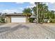 Front view of house with white garage door and landscaping at 775 Rolling Hills Dr, Palm Harbor, FL 34683