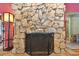 Stone fireplace with black metal screen at 775 Rolling Hills Dr, Palm Harbor, FL 34683