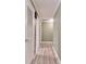 Light-colored hallway with light wood flooring and doors at 775 Rolling Hills Dr, Palm Harbor, FL 34683