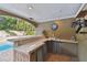 Outdoor bar with seating and sink, adjacent to pool at 775 Rolling Hills Dr, Palm Harbor, FL 34683