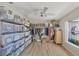 Large walk-in closet featuring a ceiling fan, wood floor, hanging clothes rack, and lots of plastic storage containers at 816 Leeward Rd, Venice, FL 34293