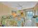 Guest bedroom with two twin beds, balcony access, and a ceiling fan at 851 Bayway Blvd # 201, Clearwater, FL 33767