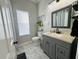 Clean bathroom with gray vanity and marble-look flooring at 9625 Fox Hearst Rd, Tampa, FL 33647