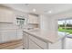 Open concept kitchen with island, white cabinets and backyard view at 9804 Crescent Moon Dr, Riverview, FL 33578