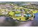 Community pool, tennis courts, and lakefront views from above at 9805 Lemon Drop Loop, Sun City Center, FL 33573