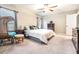 Relaxing bedroom features a king-size bed, ceiling fan, and wicker chair at 9805 Lemon Drop Loop, Sun City Center, FL 33573