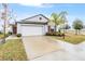 One-story home with white garage door and landscaping at 9805 Lemon Drop Loop, Sun City Center, FL 33573