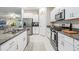 Modern kitchen with white cabinets, granite countertops, and stainless steel appliances at 9805 Lemon Drop Loop, Sun City Center, FL 33573