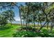 Lush green lawn, mature trees, and a scenic waterfront view at 1111 N Bayshore Blvd # B7, Clearwater, FL 33759