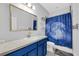 Clean bathroom with blue vanity, shower, and moon-themed decor at 11536 Tangle Stone Dr, Gibsonton, FL 33534