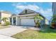 Tan house with white garage door and palm trees at 11536 Tangle Stone Dr, Gibsonton, FL 33534