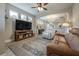 Open living room with brown leather couches and a ceiling fan at 117 W Minnehaha St, Tampa, FL 33604