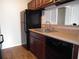 Kitchen with dark wood cabinets, black appliances, and dishwasher at 11901 4Th N St # 10105, St Petersburg, FL 33716