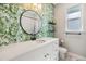 Charming bathroom with tropical wallpaper and a white vanity at 1210 E Mohawk Ave, Tampa, FL 33604