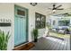 Inviting front porch with a teal door and porch swing at 1210 E Mohawk Ave, Tampa, FL 33604