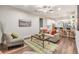 Cozy living room featuring hardwood floors, a ceiling fan, and comfortable seating at 1210 E Mohawk Ave, Tampa, FL 33604