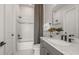 Modern bathroom with gray vanity, white tub, and black accents at 12628 Glenn Creek Dr, Riverview, FL 33569