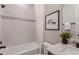 Bright bathroom featuring a shower-tub combo with stylish tiling, alongside a modern vanity with sleek fixtures and decor at 12656 Glenn Creek Dr, Riverview, FL 33569