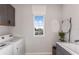 Bright laundry room with modern washer and dryer, basin, and window at 12656 Glenn Creek Dr, Riverview, FL 33569