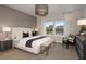 Serene main bedroom with a king bed, wood accent wall, contemporary lighting, and scenic views from the large windows at 12656 Glenn Creek Dr, Riverview, FL 33569