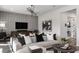 Living room with grey sectional sofa, geometric wall decor, and hardwood floors at 12664 Glenn Creek Dr, Riverview, FL 33569