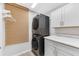 Modern laundry room with stackable washer and dryer, white cabinets, and a countertop at 12712 Mangrove Forest Dr, Riverview, FL 33579