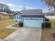 Blue house with light blue garage door and walkway, lake view at 1330 Monte Lake Dr, Valrico, FL 33596