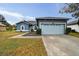 Blue house with light blue garage door, well-maintained lawn, and walkway at 1330 Monte Lake Dr, Valrico, FL 33596