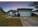 Newly painted blue house with light blue garage door and landscaped yard at 1330 Monte Lake Dr, Valrico, FL 33596