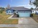 Blue house with light blue garage door and walkway at 1330 Monte Lake Dr, Valrico, FL 33596