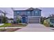 Two-story house with gray siding, teal door, and two-car garage at 13455 Jamaica Plank Loop, Riverview, FL 33579