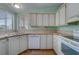 White appliances and cabinets highlight this efficient kitchen at 148 Gull Aire Blvd, Oldsmar, FL 34677