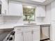 White kitchen with quartz countertops and stainless steel dishwasher at 1505 Chateaux De Ville Ct, Clearwater, FL 33764