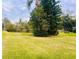 Expansive lawn with mature trees and a pond in the background at 1510 Palmer Ct, Palm Harbor, FL 34685