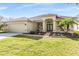 Tan house with two-car garage, well-manicured lawn, and walkway at 19106 Cellini Pl, Lutz, FL 33558