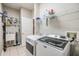 Bright laundry room with washer, dryer, and storage shelves at 19106 Cellini Pl, Lutz, FL 33558