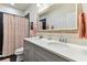 Bathroom with double sinks, gray cabinets, and a shower with a patterned curtain at 1950 Marlington Way, Clearwater, FL 33763